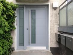 Haustür in hellgrau mit Seitenteil und Stangengriff