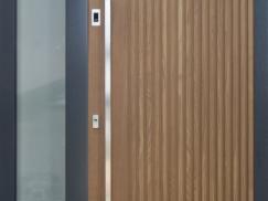 Holz-Haustür mit Stangengriff und Seitenteil mit grauem Rahmen